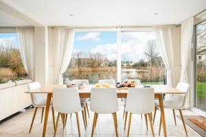 a dining room with a table and white chairs at Falcon House CW73 Lower Mill Estate Cotswolds in Somerford Keynes