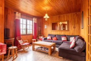 ein Wohnzimmer mit einem Sofa und einem Tisch in der Unterkunft Chalet de Charme avec vue spendide in Menthon-Saint-Bernard