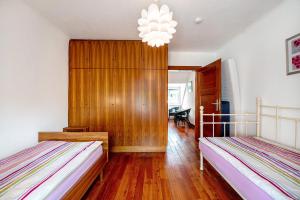 a bedroom with two beds and a chandelier at Domäne Bollinger Morbach in Morbach