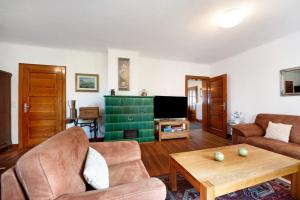 a living room with two couches and a tv at Domäne Bollinger Morbach in Morbach