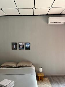 una camera con un letto con tre immagini appese al muro di Tokyo to Conakry *NONGO* a Conakry