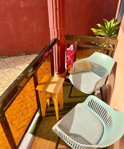 a balcony with two chairs and a table and flowers at Tokyo to Conakry *NONGO* in Conakry