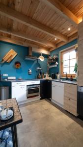 a kitchen with blue walls and a wooden ceiling at Best Boerderij B&B in Best