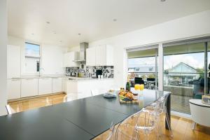 a kitchen with a large black table and chairs at Shelducks HM119 Lower Mill Estate The Cotswolds in Somerford Keynes