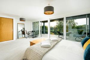 a bedroom with a bed and sliding glass doors at Shelducks HM119 Lower Mill Estate The Cotswolds in Somerford Keynes