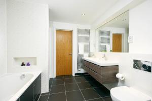 a bathroom with a sink and a tub and a toilet at Shelducks HM119 Lower Mill Estate The Cotswolds in Somerford Keynes +20 photos