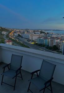 two chairs on a balcony with a view of a city at Gibel Apartments in Golem