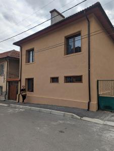 a woman standing in front of a house at Гагинската къща in Martinovo
