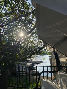 einen Blick auf das Wasser aus einem Zelt mit leuchtender Sonne in der Unterkunft Bay House Kakrc in Tivat