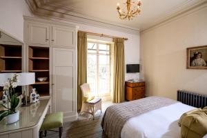 um quarto com uma cama, uma secretária e uma janela em The Bath Priory - A Relais & Chateaux Hotel em Bath