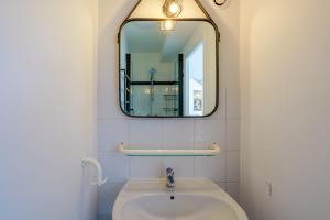 een badkamer met een wastafel en een spiegel bij Ti Louarn - Maison à 2 km de la plage in Fouesnant