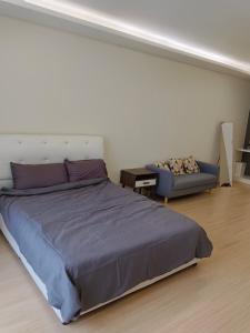 a bedroom with a large bed and a couch at Infinity homestay @ Champs Elysees kampar in Kampar