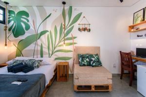 a bedroom with a bed and a chair and a desk at Econtainer Ubatuba in Ubatuba