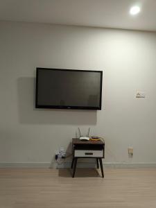 a flat screen tv on a white wall with a table at Infinity homestay @ Champs Elysees kampar in Kampar