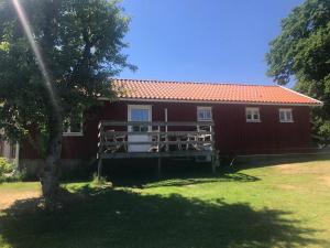 une maison rouge avec un arbre devant elle dans l'établissement Fiskebäckgårds gästhus, à Lysekil