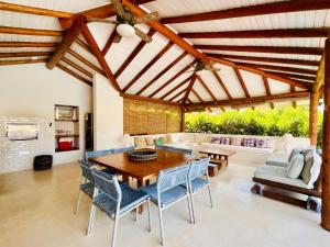 a living room with a wooden table and chairs at Casa Canada Bahia in Praia do Espelho