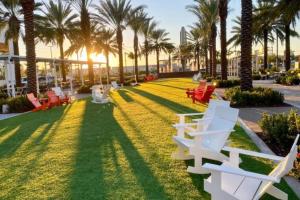 um parque com cadeiras e palmeiras na relva em Enjoy our brand new home close to Hollywood in Hallandale Beach! em Hallandale Beach