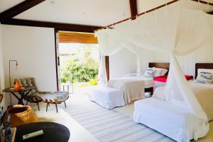 1 dormitorio con 2 camas, mesa y sillas en Casa Canada Bahia en Praia do Espelho