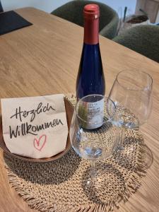 Una botella de vino y dos copas en una mesa. en Komfort FeWo l Moselstay l maximal 4 Personen und Baby I Brauneberg Mosel I WIFI I, en Brauneberg