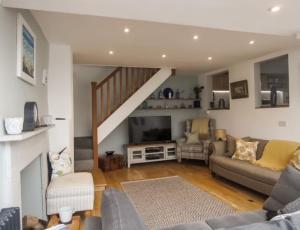 a living room with a couch and a staircase at The Cottage , Newton Ferrers in Newton Ferrers