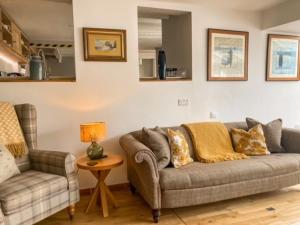 sala de estar con sofá y silla en The Cottage , Newton Ferrers en Newton Ferrers
