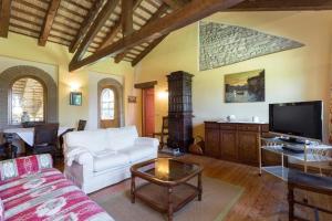 een woonkamer met een witte bank en een tv bij Ferienhaus in Aquileia mit Großem Garten in Aquiléia