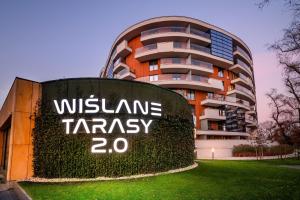 Un edificio con un cartello che legge Wyssamine Tasy di Wiślane Tarasy VIP Apartamenty JACUZZI a Cracovia