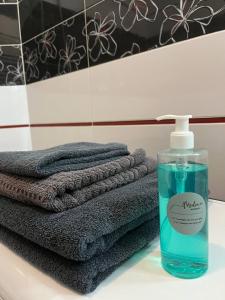 een stapel handdoeken en een fles zeep op een wastafel bij Shpytalna Apartments in Lviv