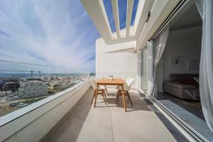einen Balkon mit einem Tisch und Stadtblick in der Unterkunft Superior Penthouse 180º views, Jacuzzi Parking in Tarifa