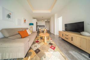 ein Wohnzimmer mit einem Sofa und einem Flachbild-TV in der Unterkunft Superior Penthouse 180º views, Jacuzzi Parking in Tarifa
