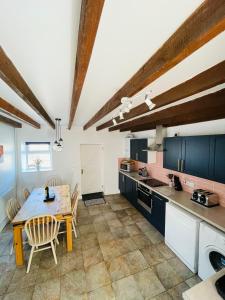 a kitchen with a wooden table and a dining room at Glyncoch Isaf Llangrannog in Llangranog