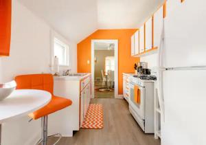 cocina naranja y blanca con nevera blanca en The Sunstone Retreat - Your Brooklyn Centre Haven Comfort To Explore Near Downtown With Parking, 300MB Wifi & Self Check-In en Cleveland