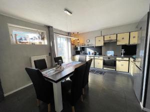 a kitchen with a table and chairs in a room at Nette Ferienwohnung in Fahretoft mit Garten, Terrasse und Grill in Dagebüll