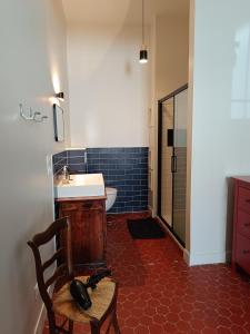 a bathroom with a sink and a toilet and a chair at Chambre d'hôtes 2 pers - Maison partagée avec jardin et terrasse près de la Friche de la Belle de mai in Marseille +16 photos
