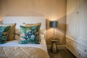 sypialnia z łóżkiem z lampką i poduszkami w obiekcie Porte House - Holiday At Home w mieście Richmond