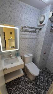 Un baño con inodoro, lavabo y espejo. en Muji Style Condo with Parking, en Manila 8 fotos más