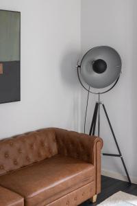 a brown couch in a living room with a fan at Master Deco Gem in Bairro Alto in Lisbon