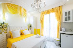 een slaapkamer met een bed met gele gordijnen en een kroonluchter bij Suite Soleil - Paris à 10 min - Apt d'exception in Deuil-la-Barre