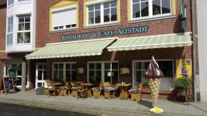 a restaurant and cafe with an ice cream cone outside at Ferienwohnungen Altstadt in Plau am See