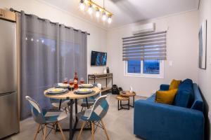 uma sala de estar com uma mesa e um sofá azul em Dina Luxury Sea View House em Aiándion