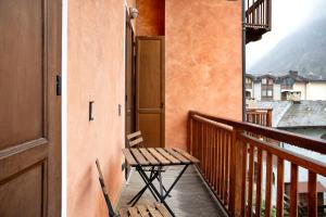 a balcony with a bench and a view of a city at Casa sul Fiume in Vernante