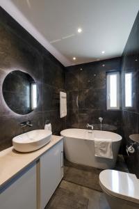 ein Badezimmer mit einer Badewanne, einem Waschbecken und einer Badewanne in der Unterkunft Lovely Penthouse In Mellieha-seaview in Mellieħa