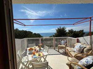 a patio with a table and chairs on a balcony at {[Apartment On The Sea +Terrace]}•Dan's house in Marina di San Lorenzo