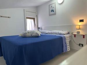 ein Schlafzimmer mit einem blauen Bett und einer blauen Decke in der Unterkunft {[Apartment On The Sea +Terrace]}•Dan's house in Marina di San Lorenzo