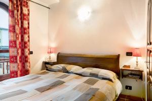 a bedroom with a bed with two lamps and a window at Casa sul Fiume in Vernante