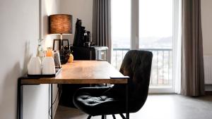 einen Schreibtisch mit einer Lampe und 2 Stühlen in einem Zimmer in der Unterkunft Si-View Doppelzimmer mit Balkon Zimmer 1 in Siegen