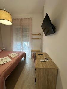 een kamer met een bed en een tv aan de muur bij B&B Zelia Napoli in Napels