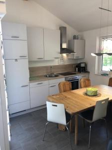 a kitchen with a wooden table and white cabinets at E21 Freistehendes Haus mit Garten und Deichblick in Butjadingen