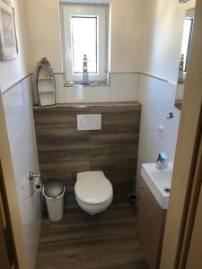a small bathroom with a toilet and a sink at E21 Freistehendes Haus mit Garten und Deichblick in Butjadingen