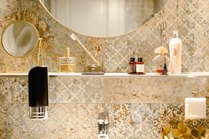 baño con lavabo y espejo en la pared en Boutiquehotel Hubertushof en Bad Ischl